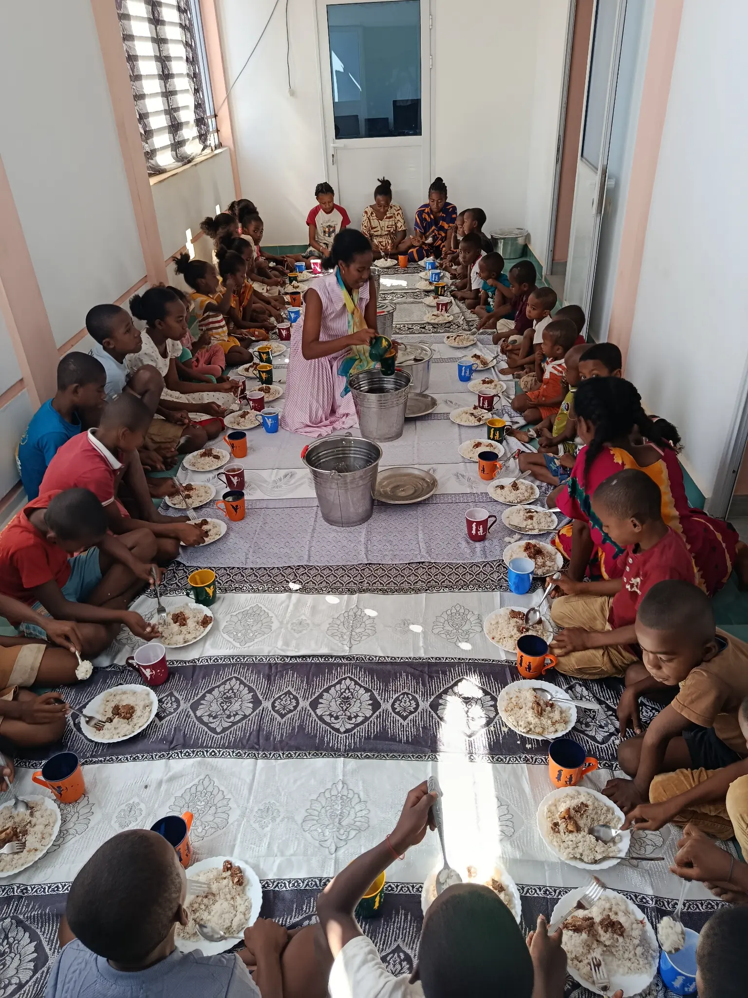 Enfants réunis autour d’un repas partagé à la cantine solidaire de l’ONG F4