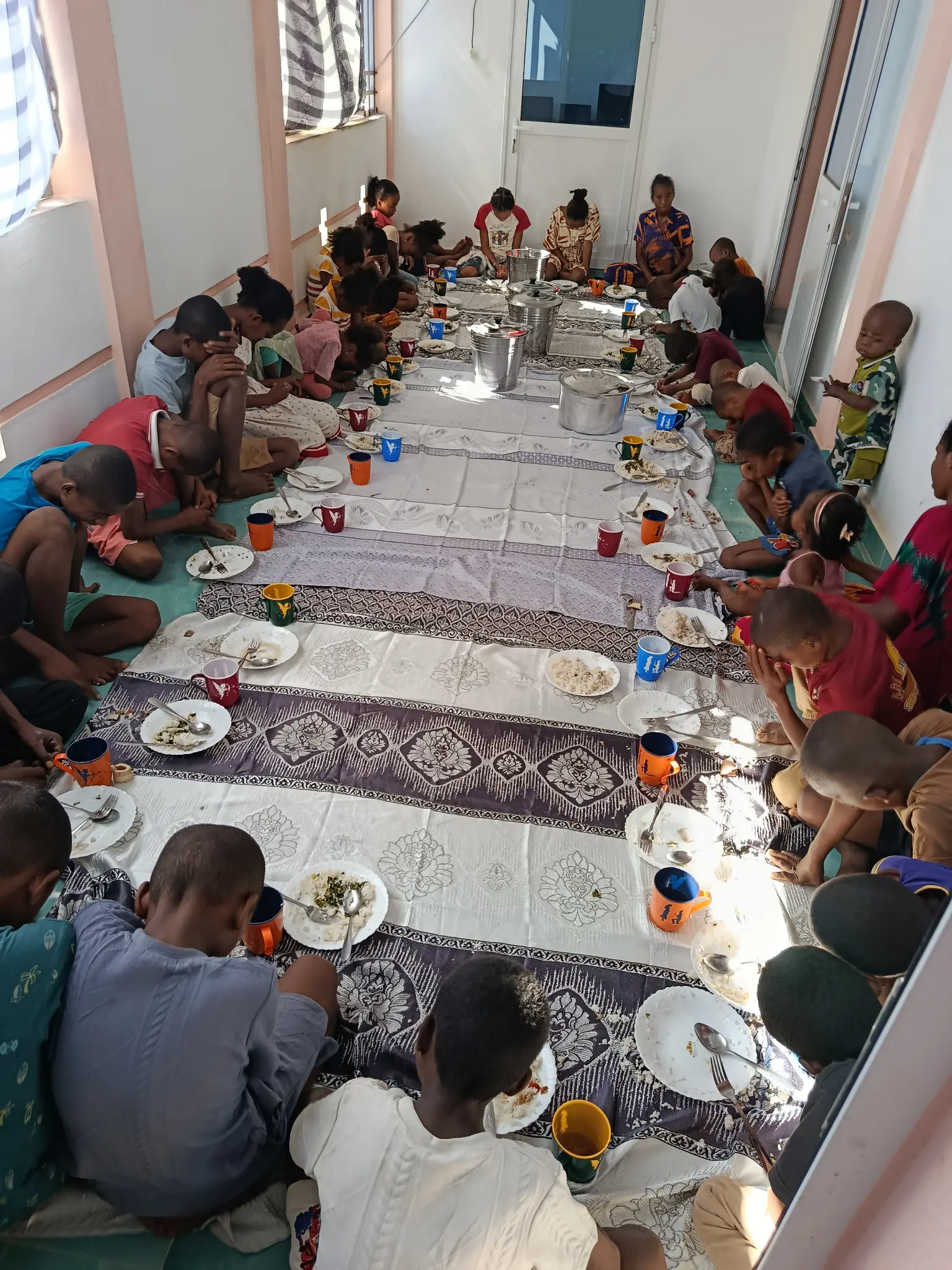 Enfants partageant un repas à la cantine solidaire