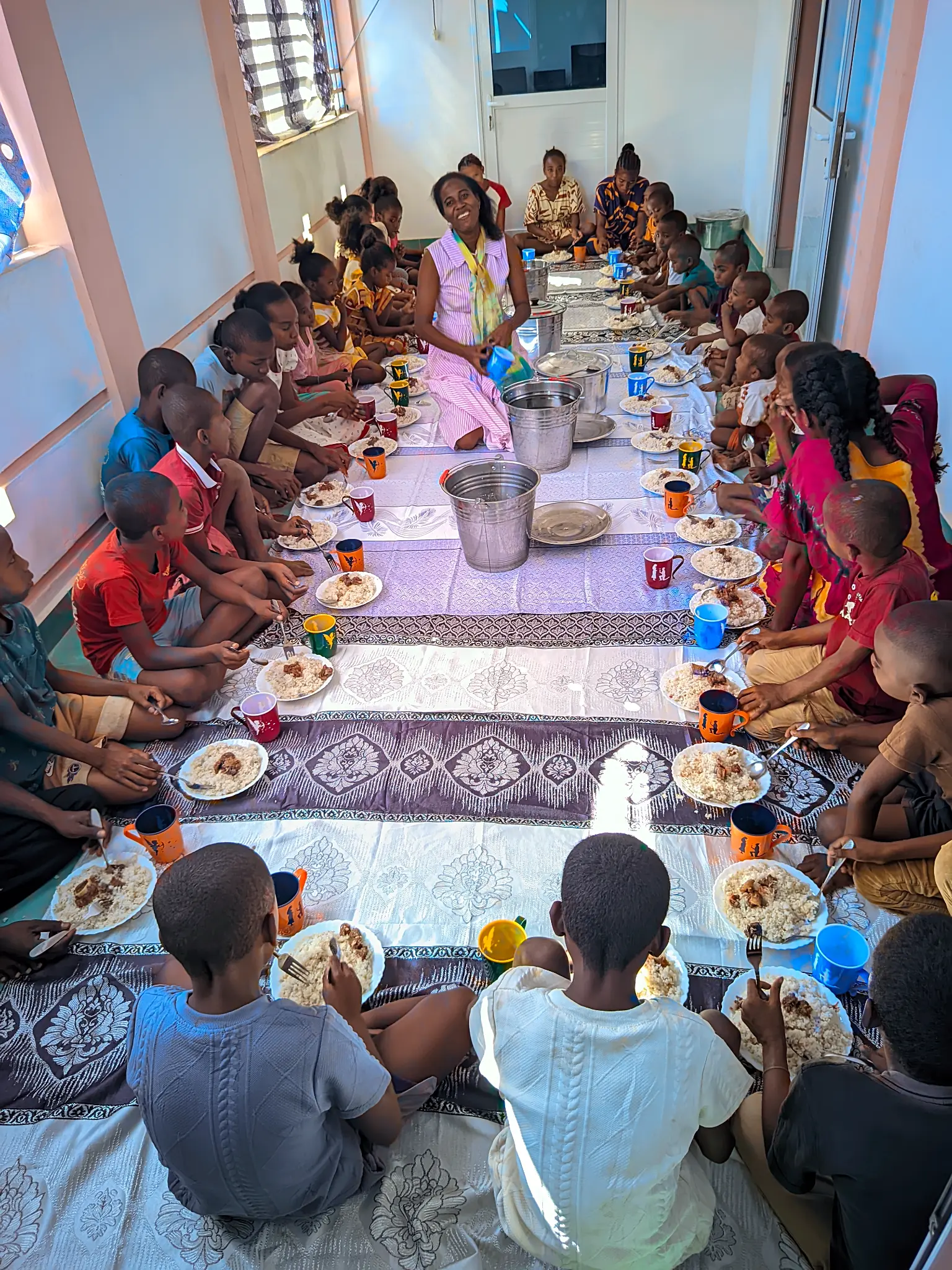 Enfants et accompagnatrice pendant un repas partagé